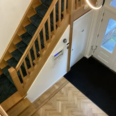 Interior view of office entryway at Utrechtseweg 47, Hilversum, featuring wooden stairs and parquet flooring, suitable for office space rental.