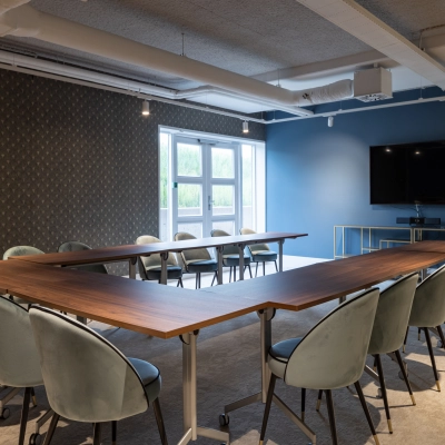 Modern conference room at Siriusdreef 60, Hoofddorp, featuring a large U-shaped table and comfortable chairs, perfect for office space rental or meetings. The room is equipped with a TV and ample natural light.