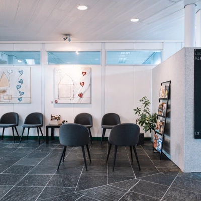 Reception area at De Vos van Steenwijklaan 75 in Hoogeveen, ideal for office space rental with a modern touch. Chairs and art adorn the space, inviting inquiries for an office to rent.