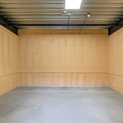 Simple interior space with light wooden walls and concrete flooring, perfect for office space rental at Hoofdveste 2, Houten.