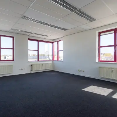 Bright office space with large windows at Sandtlaan 36, Katwijk, featuring neutral carpet and ample natural light. Ideal for leasing as office space rental.