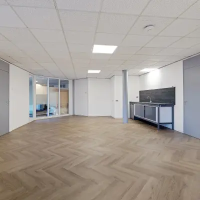 Empty office space with wooden floor and kitchenette at Ouddeelstraat 7a, Leeuwarden, ideal for office space rental.