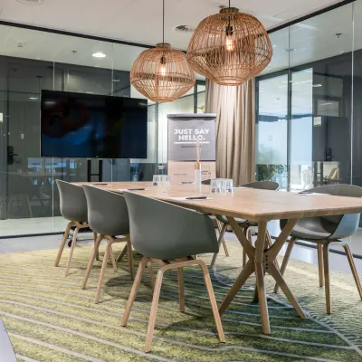 Modern conference room available for office space rental at Bargelaan 200, Leiden, featuring a wooden table, stylish chairs, and contemporary light fixtures.