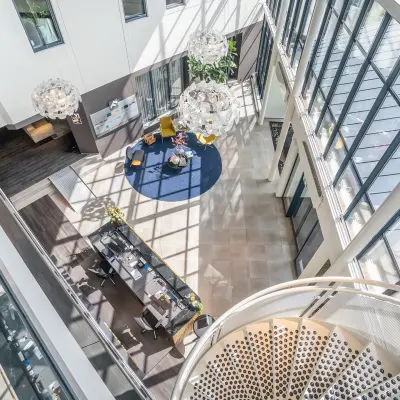 A modern office space at Kanaalpark 140 in Leiden featuring a spacious reception area with contemporary seating, plants, and decorative lighting. Ideal for office space rental.