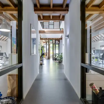 Bright office space with wooden beams, plants, and modern furnishings on Hamersveldseweg 120, ideal for businesses seeking office space rental in Leusden.