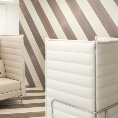 Modern office space with stylish furniture and geometric wall design, ideal for professionals seeking office space rental in Paseo de la Castellana 141, Madrid Azca.