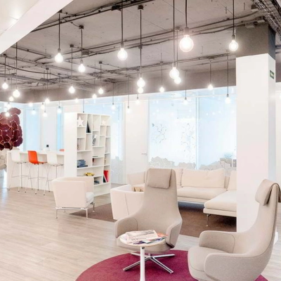 Modern office space at Paseo de la Castellana 79, Madrid Azca, with contemporary furnishings including lounge chairs and a sofa, ideal for office space rental.