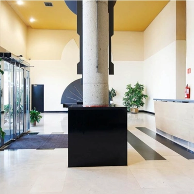 Spacious office entrance at Avenida de Aragón 334, Madrid Barajas, featuring a sleek reception desk and lush plants, ideal for office space rental.