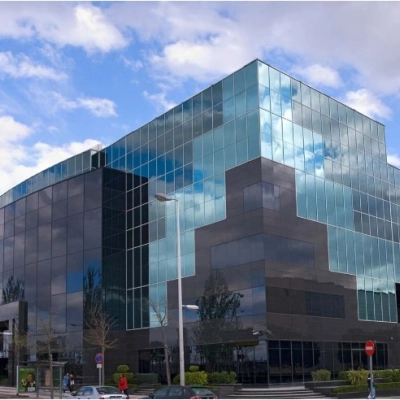Modern office building at Avenida del Partenón 16-18 in Madrid Barajas, showcasing mirrored glass facade ideal for office space rental.