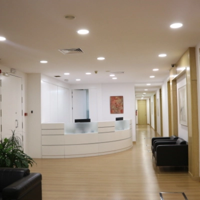 Spacious office reception area at Calle Gran Vía 6 in Madrid Center. Features a sleek front desk, seating area, and bright lighting, ideal for office space rental.