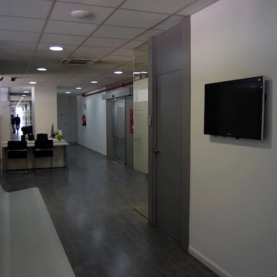 Office space in Plaza Santa María Soledad Torres Acosta 1, Madrid Center, featuring a corridor with a sleek desk, chairs, and wall-mounted TV for office space rental.