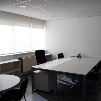 Modern, naturally-lit office to rent with sleek tables and chairs, suitable for professional workspaces in Madrid Center.