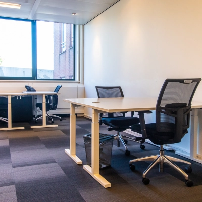 A furnished office space at Paseo de Recoletos 5, Madrid Recoletos, featuring desks and chairs, ideal for rental. The office to rent is well-lit with large windows.