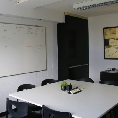 A bright conference room at De Regenboog 11, Mechelen North, featuring a large whiteboard and a modern table. Ideal for an office space rental.