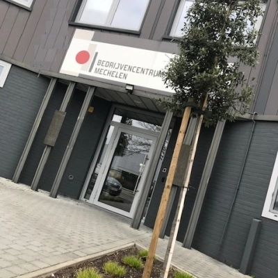 Exterior view of an office building entrance at De Regenboog 11, Mechelen North, suitable for office space rental.