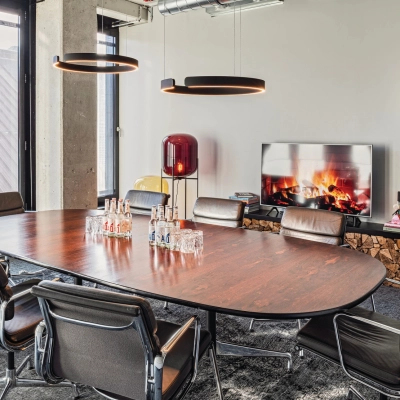 Modern conference room with a large wooden table surrounded by chairs at Rosenheimer Straße 143C. Ideal office space rental for meetings in München Werksviertel.