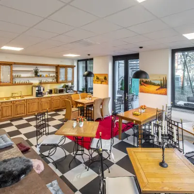 Bright office space at Landsberger Straße 155, Munich Laim, featuring a cozy lounge with checkered floors and wooden furniture ideal for office space rental.