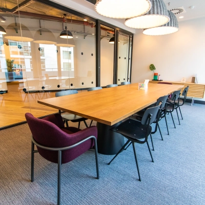 Spacious office to rent at Oskar-von-Miller-Ring 20, Munich Maxvorstadt, featuring a modern conference room with a large wooden table, black chairs, and decorative lighting, perfect for office space rental.
