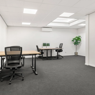 Modern office space for rent at Nijverheidsweg 9B, Nieuwegein, featuring desks, chairs, and a potted plant under skylights for bright natural lighting.