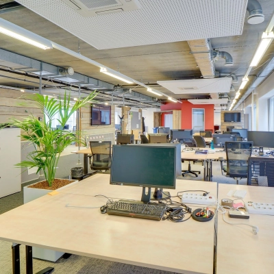 A spacious office interior on Zoomstede 19, Nieuwegein, featuring open workspaces with multiple desks, computer monitors, and a potted plant under modern lighting. Ideal for office space rental.
