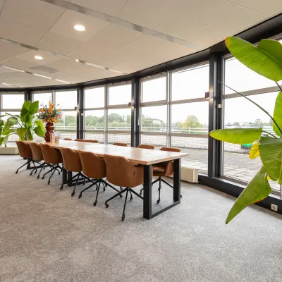A furnished office space at Patroonstraat 13, Nijkerk, featuring large windows and modern furniture. Ideal for those looking for office space rental with natural light and contemporary design.