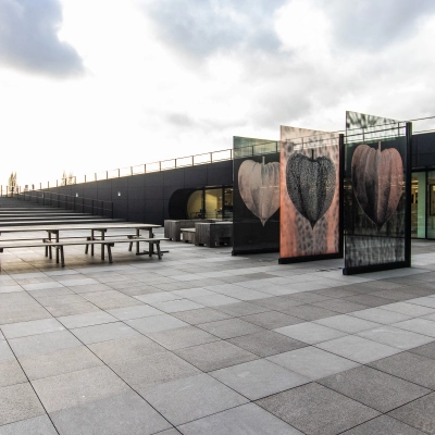 Exterior view of an office space at Jonkerbosplein 52, Nijmegen, showcasing a modern design with ample outdoor seating. Ideal for those looking to rent office space.