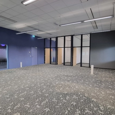 Spacious office to rent at Veengang 1, Oosterwolde, featuring patterned carpet, large windows, and ample natural light.