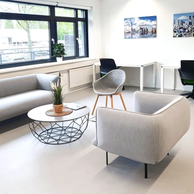 Spacious office at Einsteinlaan 28, Rijswijk features modern furnishings, including sofas and individual desks, ideal for office space rental. Large windows provide natural light.