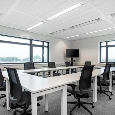 Office space rental at Einsteinlaan 28, Rijswijk, featuring a furnished room with a long table and chairs, perfect for group meetings or collaborative work.