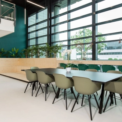 Modern office space for rent at Einsteinlaan 28 in Rijswijk, featuring a spacious furnished interior with a long conference table and large windows letting in natural light.