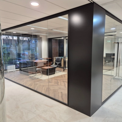 Modern office space rental located at JC van Markenlaan 3, Rijswijk, featuring glass walls, stylish wooden flooring, and contemporary seating arrangements.