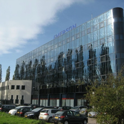 Modern office building with reflective glass facade at Patrijsweg 62, Rijswijk, surrounded by trees and a parking area. Ideal for office space rental.
