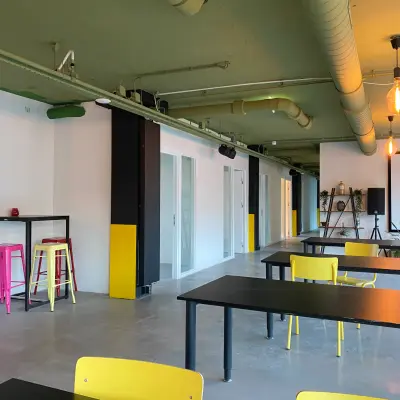 Bright and modern office space with yellow chairs and black tables, ideal for those seeking office space rental at Volmerlaan 7, Rijswijk.
