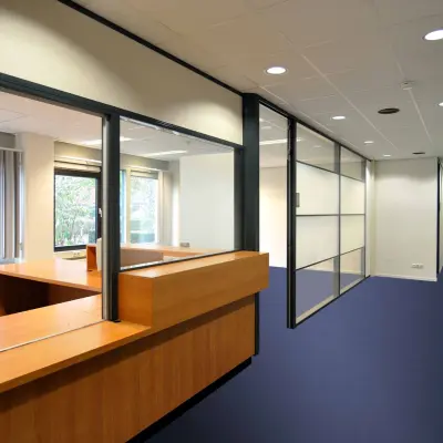 Interior view of an office space rental at Laan van Brabant 70-86, Roosendaal, featuring glass partitions and wooden desks.