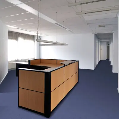 Interior view of office space available for rent at Laan van Brabant 70-86, Roosendaal. The room features a central wooden partition with overhead lighting, ideal for storage or flexible office space rental.