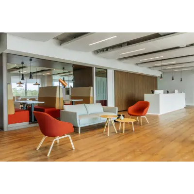 Modern office space for rent in Rotterdam Alexander with a stylish lounge area, featuring colorful chairs and wooden tables; perfect for casual meetings or relaxation.