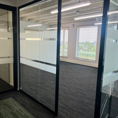 Office space available for rent at Bahialaan 100, Rotterdam Brainpark, featuring glass partition walls and carpet flooring with abundant natural light.