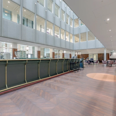 Spacious office in Rotterdam Center at Blaak 34 featuring a modern interior with seating and a contrasting wooden floor, ideal for office space rental needs.