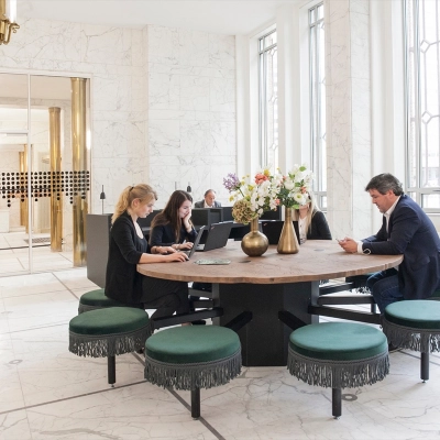 Office space rental at Blaak 34, Rotterdam Center, featuring a round table with people working on laptops.
