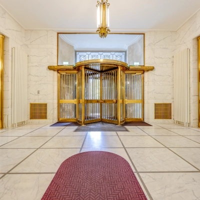Spacious office entrance at Blaak 34 in Rotterdam Center, ideal for office space rental with its elegant design and revolving doors.