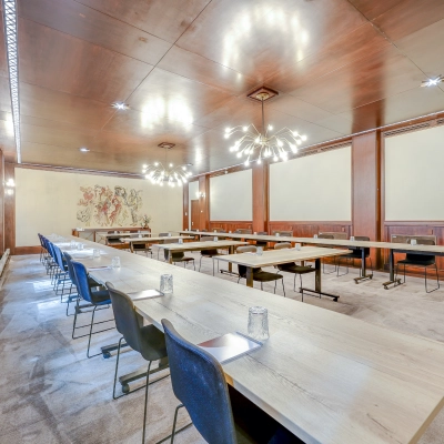 Spacious conference room in Rotterdam Center, Blaak 34, available for office space rental. Tastefully furnished with modern lighting, long tables, and chairs, perfect for meetings.