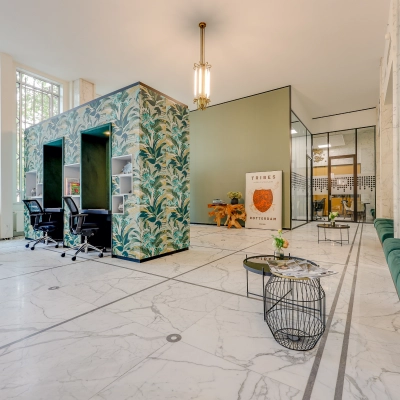 Spacious office to rent at Blaak 34, Rotterdam Center featuring modern decor with accent walls, seating area, and ample natural light for a vibrant work environment.
