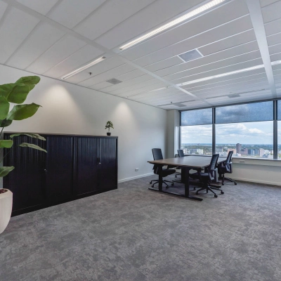Bright, furnished office space at Blaak 555, Rotterdam Center, featuring large windows, modern furniture, and a city view. Ideal for office space rental.