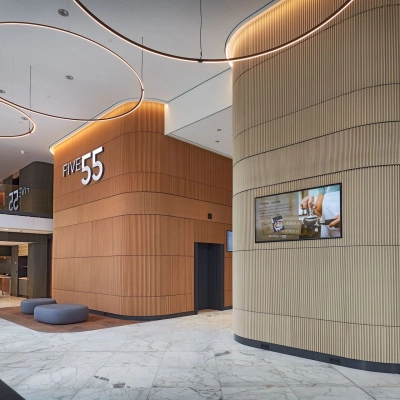 Modern office lobby at Blaak 555, Rotterdam Center with wooden accents and LED lighting, ideal for rent office space.