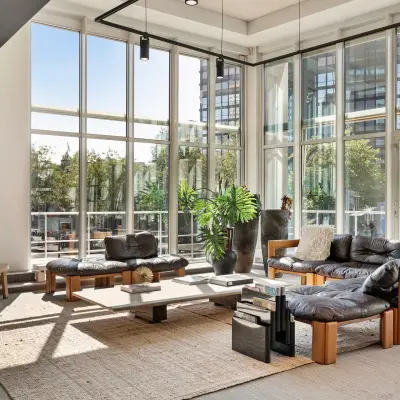 Bright office space at Coolsingel 104 in Rotterdam Center with large windows, modern furniture, and a cozy seating area ideal for meetings. Ideal for office space rental.