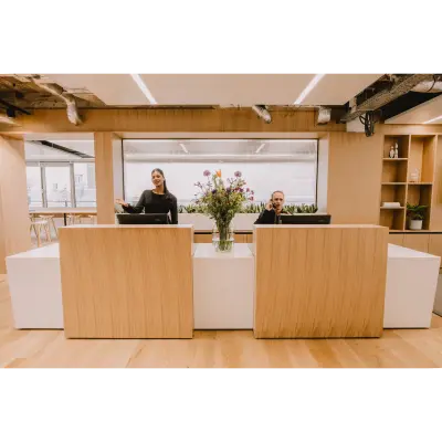 Modern office reception area at Coolsingel 65, Rotterdam Center, with two people at the desk, ideal for office space rental inquiries.