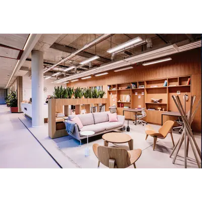 Modern furnished office space for rent at Hoogstraat 185, Rotterdam Center, featuring stylish seating and workspaces with plants and shelves for a comfortable office space rental experience.