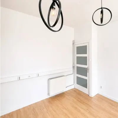Bright, unfurnished office space at Mauritsweg 33 A01, Rotterdam Center, featuring modern light fixtures and wooden flooring, ideal for office space rental.
