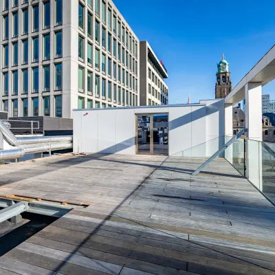 Spacious outdoor deck at Stadhuisplein 9-23, Rotterdam Center, offering potential for an office space rental with views of surrounding buildings.
