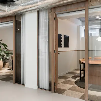 Modern office to rent at Stadhuisplein 9-23, Rotterdam Center, featuring glass-walled workspaces and stylish furnishings, ideal for productive meetings and collaborations.